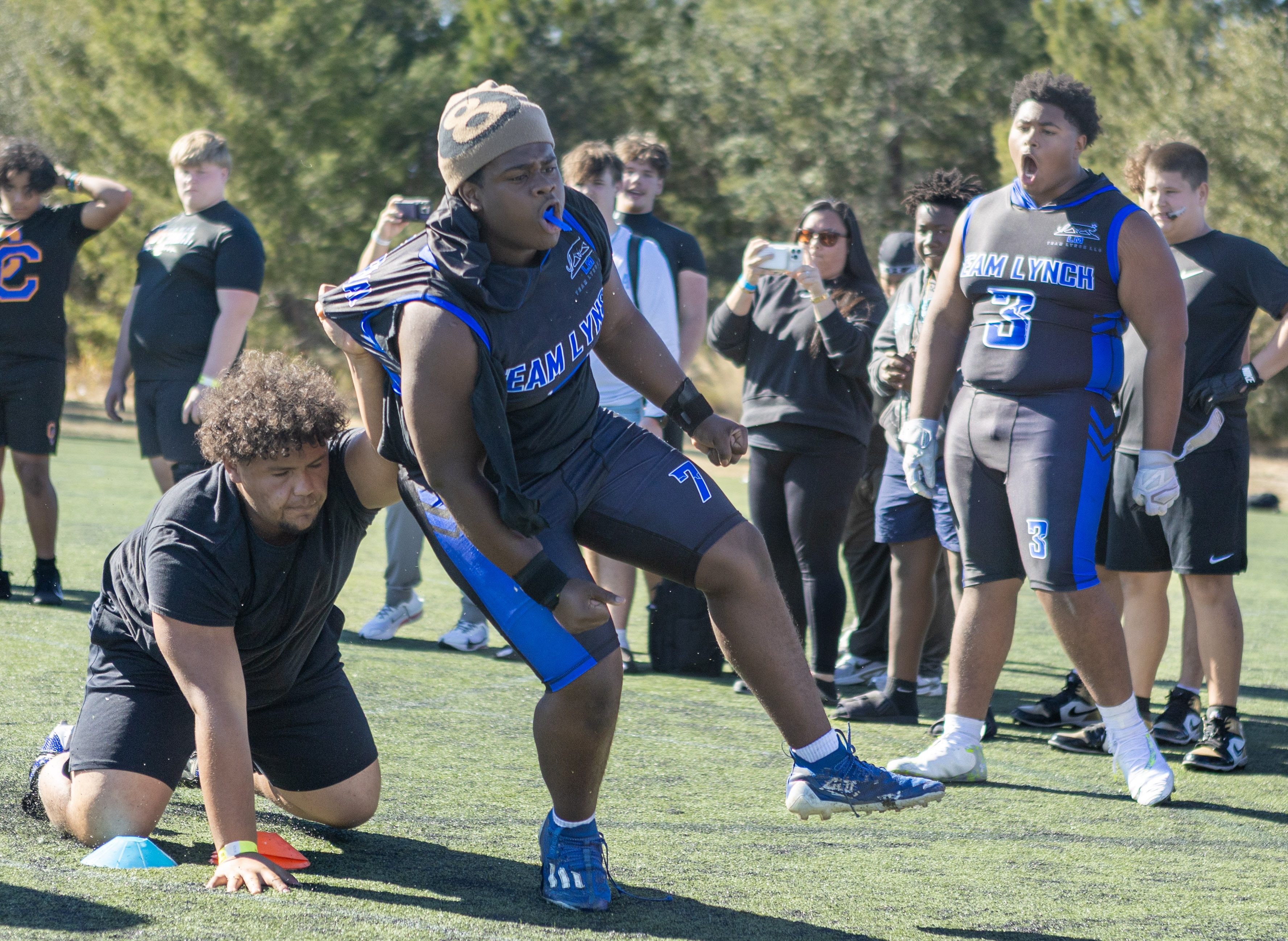 Linemen competing while families record from the sideline